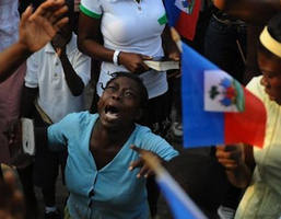 Image of A woman takes part in an open air mass in Port-au-Prince on January 24, 2010. More than 110,000 people have been confirmed as killed in Haiti's devastating earthquake, the Interior Ministry said, making it the deadliest on record in the Americas.