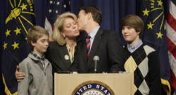 Image of Senator Evan Bayh of Indiana surrounded by his family as he announces he will retire from the Senate.