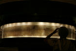 Image of A visitor views the original scrolls on display.