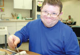 Image of Craig, a happy resident of the DPD works on a craft project. 