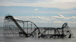 Image of A roller coaster now sits in the ocean following the destruction of its supporting pier. The fact the structure remains intact is a testament to its designer. 