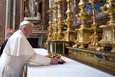 Image of Pope Francis placing flowers at the altar