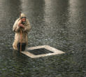 Image of A pilgrim waits in yesterday's rain for the announcement that a new pope has been chosen. The pilgrim represents all of the faithful who wait in prayer. 