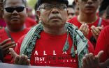 Image of A Muslim wearing a shirt in support of the ban on non-Muslim use of the Arabic word for God.