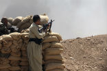 Image of Kurdish fighters stand watch in northern Iraq for fighters from the Islamic State.