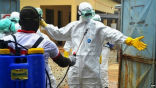 Image of Health workers in Guinea being decontaminated after handling potentially Ebola infected materials.