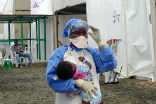 Image of An aid worker carries a child infected with Ebola in Liberia, one of the West African nations hardest hit by the outbreak.
