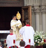 Image of There is also an ancient and beautiful custom in the Latin Rite of the Catholic Church called the Corpus Christi procession. The consecrated Host, the Body of the Lord, is reposed in what is called a monstrance. The term is derived from a Latin phrase which means to show or reveal.  The faithful process the Body of the Lord through the streets surrounding their church buildings. This Eucharistic procession can be a powerful witness to an age which has lost its sense of the sacred. 