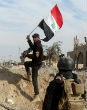 Image of Iraqi troops raise the country's flag in the government center of Ramadi. 