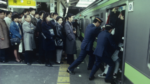 Tokyo is so crowded that special workers cram people into the subway trains there.