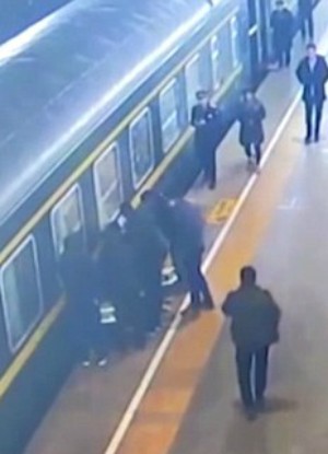 Passengers rally together to pull the child from the tracks (CGTN/YouTube).
