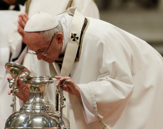 Pope Francis inspects a jar of holy oil during the Chrism Mass.