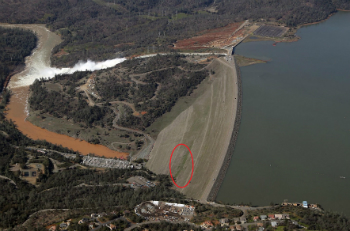 The green area on the face of the dam suggests water is seeping though the dam.