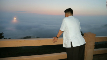Kim Jong Un views a launch from a distance.