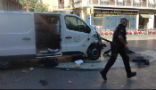 Image of An officer walks past the van used in the attack. 