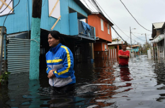 People walk though flooded streets in the aftermath of Maria. Several places remain flooded.