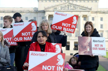 Pro life campaigners gather with placards at Parliament buildings on the Stormont Estate in Belfast