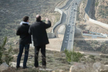 Image of A bishop of the Holy Land Coordination surveys the construction of the separation wall in Palestines Cremisan Valley