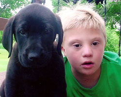 Image of BOY WITH DOWN SYNDROME POSES WITH DOG AT NORTH DAKOTA HOME
Colten Schneider poses with his dog D.J. at his home in Fargo, N.D. The 8-year-old boy, who with his family attends St. Anthony Church in Selz, has Down syndrome. He struggles to express himself verbally, but his family and his friends almost always kno w exactly what he is saying. (CNS photo/courtesy Schneider family).
