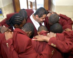 Image of FIRST GRADUATING CLASS The first seven graduates of Nativity Preparatory School huddle together to celebrate their middle school graduation. (The Dialog photo)
