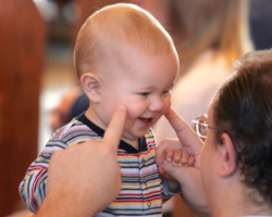 Image of FATHER AND SON SHARE A LIGHT MOMENT DURING MASS – A father and his young child share a light moment during a 2005 Mass at St. John Vianney Church in Prince Frederick, Md. Fathers receive special recognition on Father's Day, which falls on in many countries including the United States on June 18 this year. (CNS) 