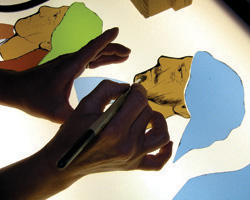Image of STAINED-GLASS ARTIST WORKS IN VERMONT STUDIO - Stained-glass artist Debora Coombs adds shading to a figure in one of her works in her Readsboro, Vt., studio. The British-born artist works in the studio that's about 20 feet by 30 feet, a former garage her husband converted for her work after they moved to this rural area about 10 years ago. Stained-glass windows, she says, are 