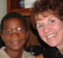 Image of SISTER PARISH PROVIDES OPTICAL SUPPORT: Sally VanBuskirk (right), a leader volunteer for the Jamaica Outreach Program, sits with one of the children that was given glasses as part of the eye care program at St. Pius X parish in Kingston, Jamaica. (Photo/Jamaica Outreach Program)
