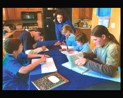 Image of THERE'S NO PLACE LIKE HOME: Sue O'Hanlon (standing) teaches her children at home in Clayton, Del. Attending class (clock-wise from bottom left) are David, Drew, Mary Beth, Teresa and Skylar. O'Hanlon calls her 12-year experience in home schooling 