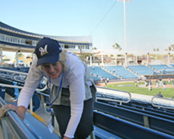 Image of SPRING TRAINING FUND RAISER - Reene Bertone cleans the bleachers March 1 at Maryvale Stadium where the Milwaukee Brewers hold spring training. She staffs the games with dozens of volunteers to raise money for St. Vincent de Paul Parish. (The Catholic Sun) 
