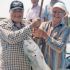 Image of FISHER OF MEN... AND FISH - Msgr. Larry Stuebben and Anthony Kallina display the monsignor’s prize catch on a fishing expedition at Port O’Connor, a pastime he squeezes into his still very active ministry schedule for the archdiocese. 