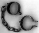 Image of Real chains are unnecessary in the modern era as slaves are bound by cultural stigma and fear.  