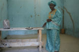 Image of Slalaka Djike stands in the jail cell where she was held for three days awaiting punishment. 