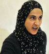 Image of Zubeidat Tsarnaeva scowling during an interview with the press. Tsarnaeva denies that she is radicalized but believes 9/11 is a plot to make Americans hate Muslims because she read about it online. 