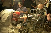 Image of Pope Francis kissing a baby's feet.