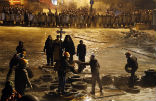 Image of Ukrainian Catholic priests pray for peace amid violent clashes between protesters and police. 