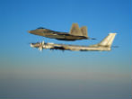Image of An American F-22 escorts a Tu-95 bomber away from US airspace. 