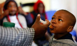 Image of A boy is given a dose of medication in a South African clinic. Despite the progress of the past year, much more remains to be done. Doctors are hopeful however, the nation has turned a corner. 