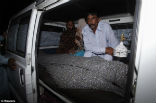 Image of Mohammed Iqbal sits with his wife's body after the police completed their investigation of the scene. 