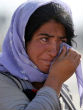 Image of A Yazidi woman cries in a refugee camp where most of her surviving people now live. 