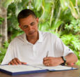 Image of Obama signs a bill while on vacation. 