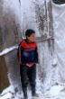 Image of A refugee child shivers in the cold. Even behind the makeshift canvas walls, it isn't much warmer. 