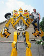 Image of Wang Liansheng stands on his 16-foot-tall model of autobot Bumblebee.

