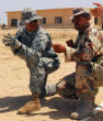 Image of U.S. soldier teaches Syrian rebel which way to hold his weapon (U.S. Army).