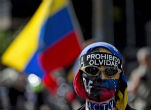 Image of A protestor wears a bandana that reads, 'prohibited to forget.'