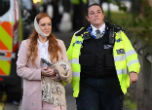 Image of An injured woman is escorted away from the site of the attack where 22 people were injured. 