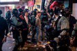 Image of Riot police detain two men after clearing protesters from the Central district in Hong Kong